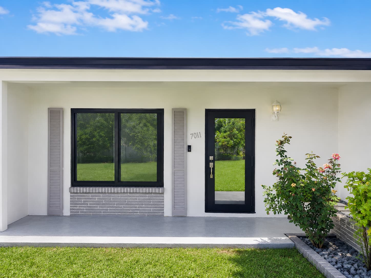 Completed front elevation with a new black-framed impact window and entry door