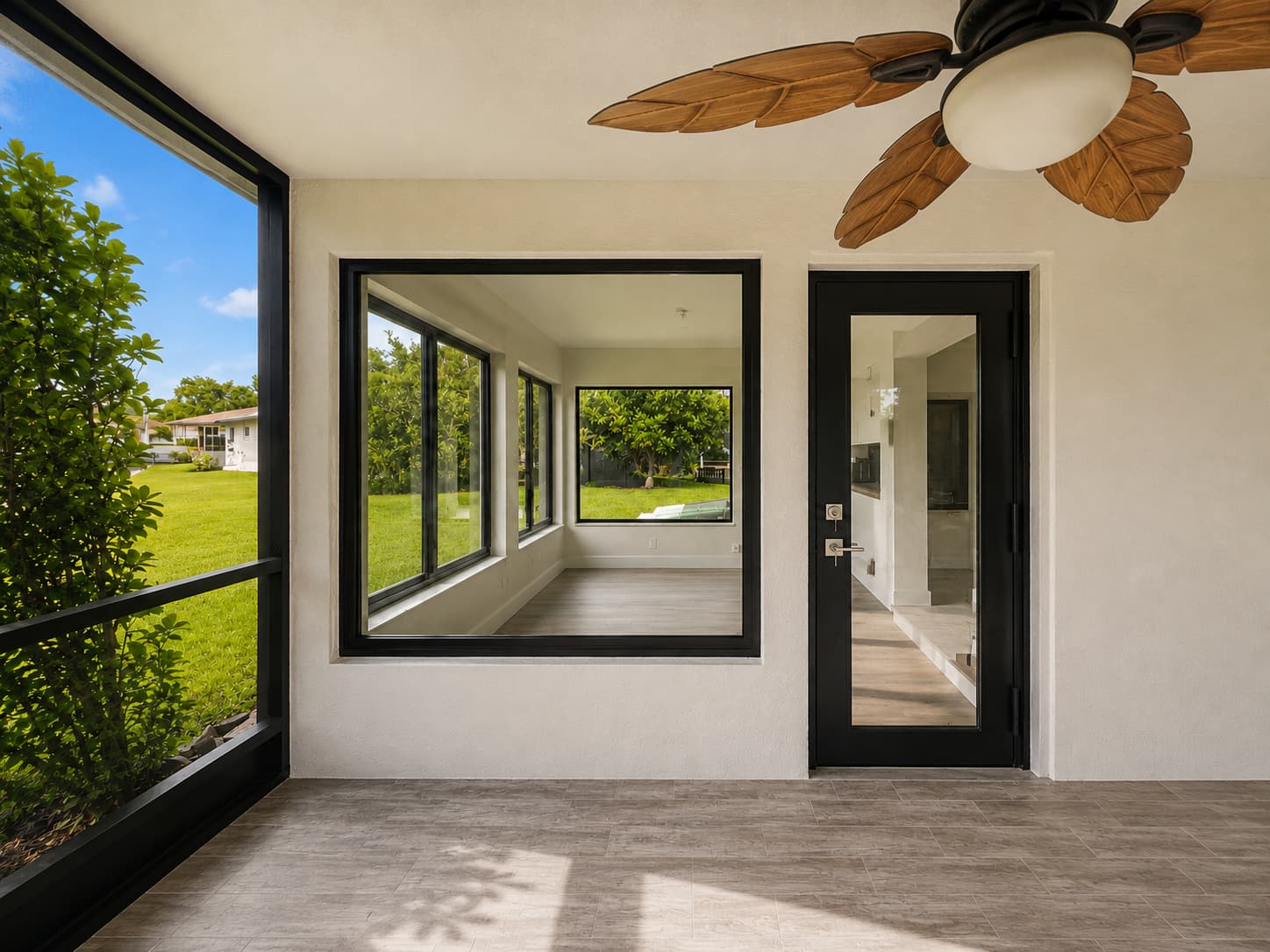 Large-format impact glass and glazed door opening onto a covered patio